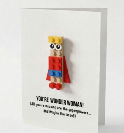  "Wonder Woman Lego figure postcard, yellow blonde hair, red blue costume, superhero character, multilingual greeting card"
