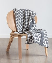 Soft, cozy throw blanket with a geometric pattern in shades of gray and white. Made of high-quality materials, suitable for use on a couch or bed.