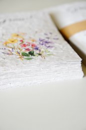  Colorful floral design on a white paper product. Includes various flowers and plants in a natural, hand-painted style.