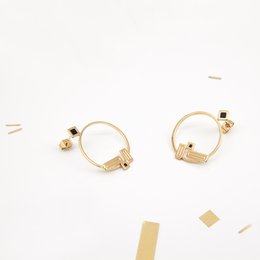 Stud earrings in various colors including Prusse, Ambre, Aniline, Corail, Blanc, Noir, Nude, Midnight Blue, Mousse, Brique, Sable, and Massaï. The earrings feature a simple, minimalist design with a circular shape and a small accent detail.