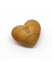 Wooden heart-shaped statue with the text "Gib nicht auf!" (Don't give up!) carved into it. The statue is placed on a bed of purple flowers.