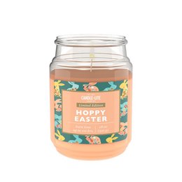 A large, round, glass candle jar with a floral pattern label that reads "Hoppy Easter - 510g". The candle is a light peach color.
