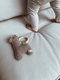 Soft, cuddly alpaca rattle in neutral tones of ecru, taupe, rust, and ochre. Handcrafted with care for a unique, natural baby toy.