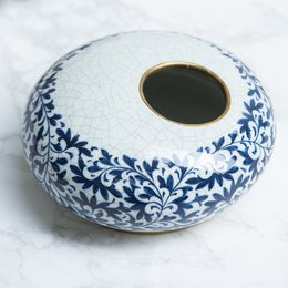 Round, ceramic vase with blue and white floral pattern. Suitable for home decor or as a decorative accent piece.