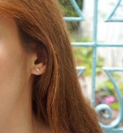 Tiny sterling silver stud earrings with a minimalist, nature-inspired design.