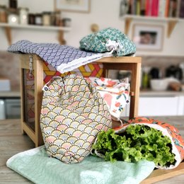 Reusable produce bag with geometric pattern, holds fresh green lettuce.