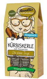 Roasted pumpkin seeds with ginger and caramel flavor, packaged in a 6-pack carton or 1kg open bag. The product features an illustrated character on the packaging.
