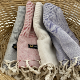 Soft, absorbent hand towels in a variety of neutral colors including red, anthracite, beige, and plum. Made of high-quality materials with a stylish woven pattern and fringed edges.