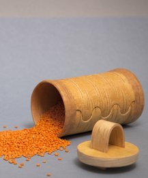 Wooden storage jar with lid, used to store sugar or other dry goods. Cylindrical shape with textured surface, made of natural materials.