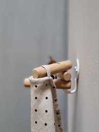 Oak and white 3-in-1 hook for hanging towels, robes, or other items. Wooden construction with a modern, minimalist design.