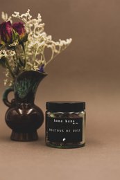 Dried rosebuds in a vase with a black jar labeled "Bana bang... Bringing us home."