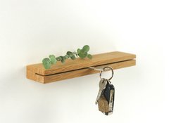 Wooden key rack with hooks for hanging keys. Rectangular shape, natural wood finish, simple and functional design.