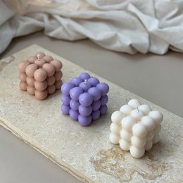 Set of 3 decorative bubble candles in creme, beige, and lilac colors. Spherical, bubble-like shapes with a smooth, waxy texture.