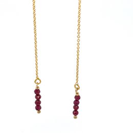  Gold-toned pull-through earrings with a vertical row of deep red garnet gemstones.