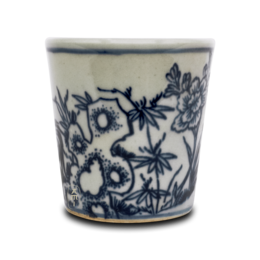 A blue and white ceramic coffee cup with a floral and animal pattern.