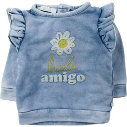 The product is a kids' sweater with a floral design and the text "Hola amigo" printed on it. It is made of a soft, denim-like material and has ruffle details on the shoulders. The sweater comes in a range of sizes from 62 to 104 cm.