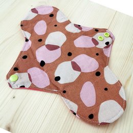 Washable sanitary towel with an abstract floral pattern in shades of brown, pink, and green.