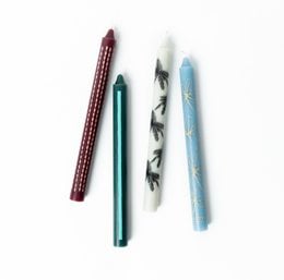 Set of 4 tall, cylindrical dinner candles in sunset cabana print pattern. Candles are made of wax and have a smooth, glossy finish.