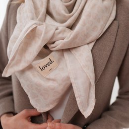  Soft, lightweight muslin cloth scarf in rose/off-white color with "loved" text detail. Versatile accessory for casual or formal wear.