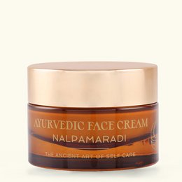  Ayurvedic face cream in a round glass jar with a gold lid. The cream is a natural, herbal formula for skin care.