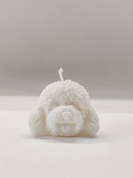 Small, fluffy white dog-shaped candle with a round, pom-pom-like design. Suitable for use as a decorative pillar candle.