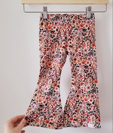 Flared kids pants in a colorful floral print pattern, available in sizes 74/80 to 122/128.