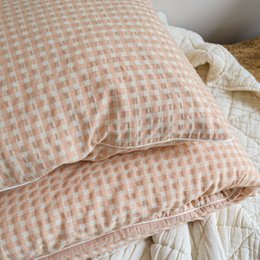  Soft, peach-colored duvet cover with a subtle checkered pattern, perfect for adding a cozy and stylish touch to any bedroom.