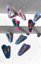 Colorful resin hair clip with glitter and crushed glass accents, suitable for kids.