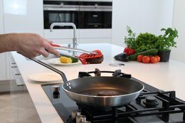 Black stainless steel kitchen multitool with stingray design, includes whisk functions.