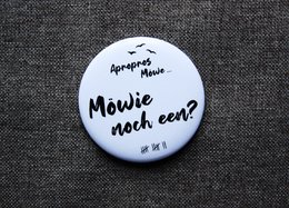 Magnetic bottle opener with "Möwie noch een?" text in Low German, diameter 5.6cm.