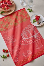 Red and gold jacquard tea towel with strawberry shortcake design, featuring a cake stand and floral patterns.