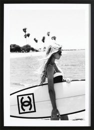 Chanel surfboard poster, featuring a woman holding a surfboard on the beach. Available in various sizes.