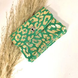  A compact, green wallet with a leopard print pattern. The wallet features a zipper closure and a small metal charm or decoration.