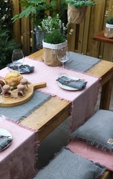 This handmade table runner is made of denim-grey or sahara-colored fabric, measuring 40x150 cm. It features a fringed design and is suitable for use on tables.