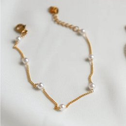 A delicate gold-toned anklet with small pearls, perfect for adding a touch of elegance to any outfit.