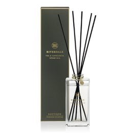  Green reed diffuser with tea and cardamom scent, packaged in a glass bottle with black reeds.