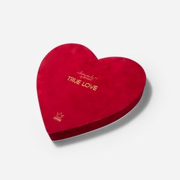 A heart-shaped red velvet gift box with the text "True Love" printed on it. The box contains chocolates and a single red rose, creating a romantic and thoughtful gift for a special occasion.