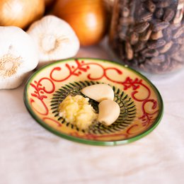  Rustic ceramic plate grater in green with decorative patterns, suitable for grating cheese.