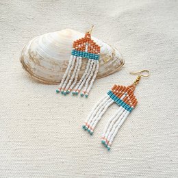  Handmade terracotta earrings with intricate beadwork in vibrant colors and patterns, featuring a statement design.