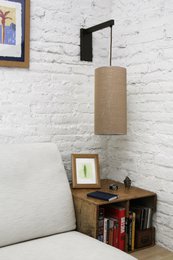  A black, rectangular wall lamp with a linen or canvas shade. The lamp has a simple, minimalist design and is suitable for modern or industrial-style interiors.