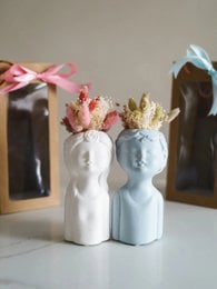 White ceramic vases with floral crowns, available in white and blue colors.
