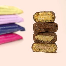 Assorted chocolate pralinis with various fillings including salted peanut butter, cashew choc caramel, hazelnut choco nougat, and raspberry almond caramel.