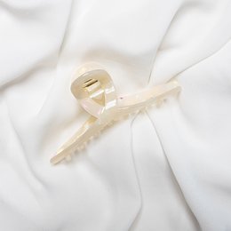 Beige hair claw clip with a twist design. Made of durable plastic material.