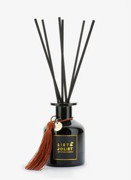 Scented reed diffuser with a dark glass bottle and black reed sticks. The diffuser has a tassel accent and the label reads "Life is sweet".