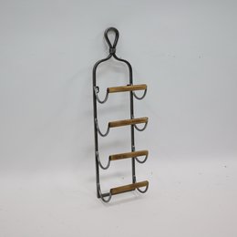 A metal and wood wine rack in a silver finish, featuring a hanging design with four shelves to hold wine bottles.