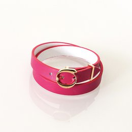  Fuchsia and white leather cuff bracelet with a circular metal accent.