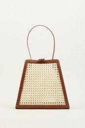 Brown leather handbag with woven beige body and brown trim. Trapezoid shape with top handle.
