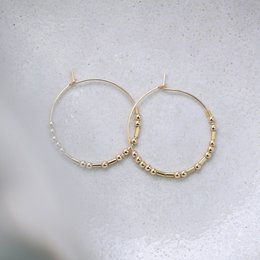 Hoops Fernweh - Gold-tone hoop earrings with beaded accents

The image shows a pair of gold-tone hoop earrings with small beaded accents along the hoop. The earrings have a simple, minimalist design that would complement a variety of outfits. The beaded details add a touch of texture and visual interest to the classic hoop shape.
