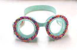 Colorful, donut-shaped swim goggles with a playful, fun design for kids. Features a pink frame with multicolored sprinkle-like accents.