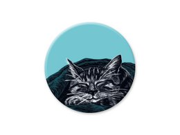 A round, teal-colored magnet featuring a close-up illustration of a black and white cat with a grumpy expression.